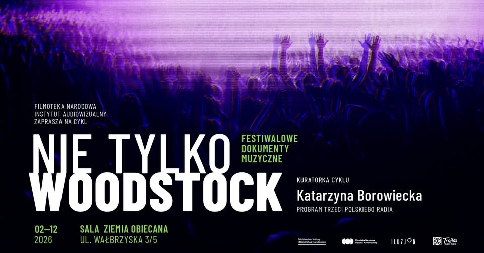 Tłoczny wieczorny koncert na świeżym powietrzu; reflektory sceniczne rzucają ciepłe bursztynowe i fioletowe barwy na wiwatującą publiczność, energetyczna atmosfera i sylwetki zespołu występującego pod girlandami świateł